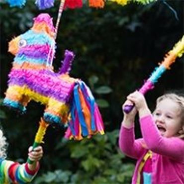 Un niño con los ojos vendados va a romper una celebración de cumpleaños de  piñata accesorios y regalos brillantes